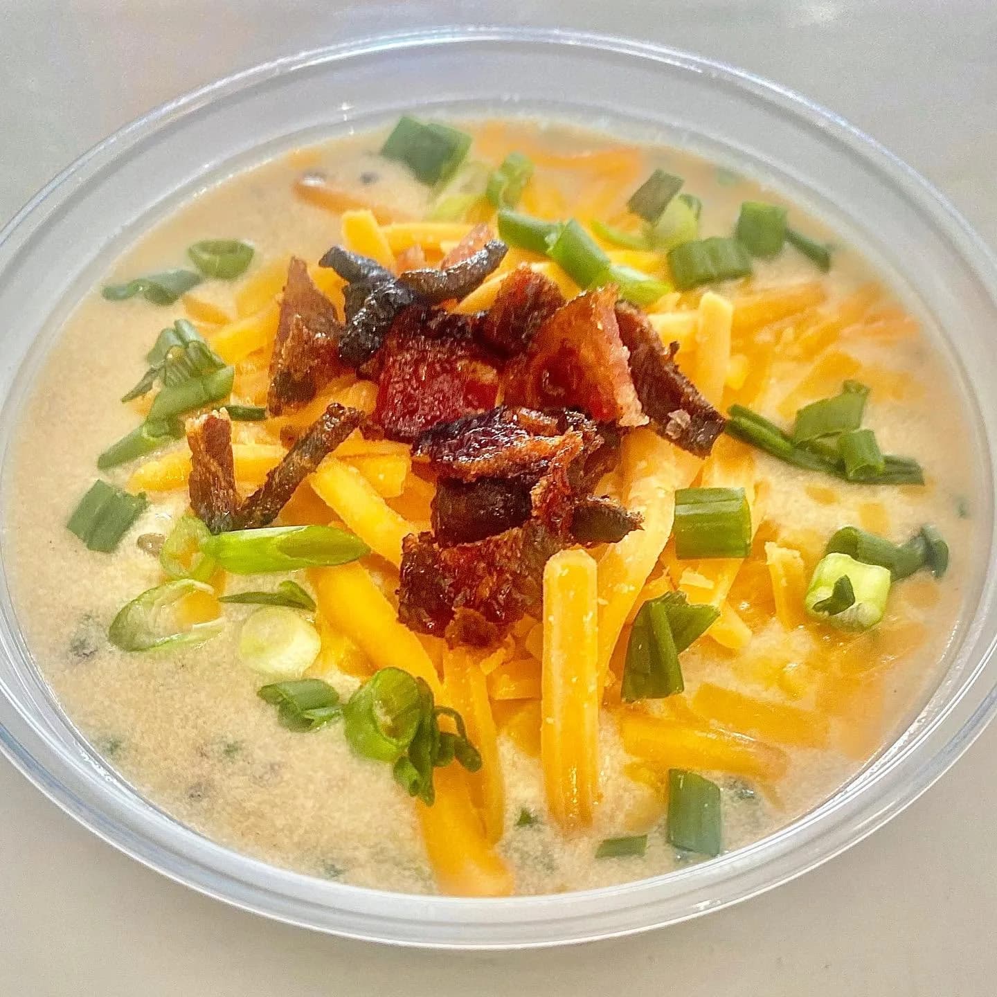 A bowl of loaded potato soup with bacon, cheddar and green onion