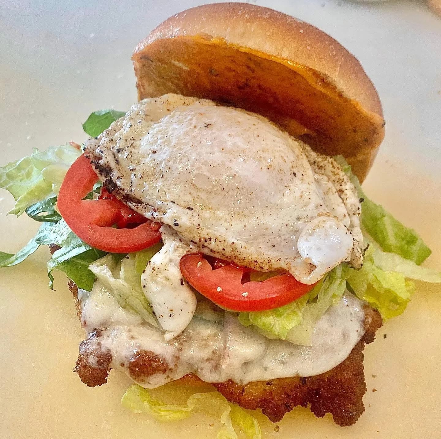 A sandwich with a fried egg, lettuce and tomato