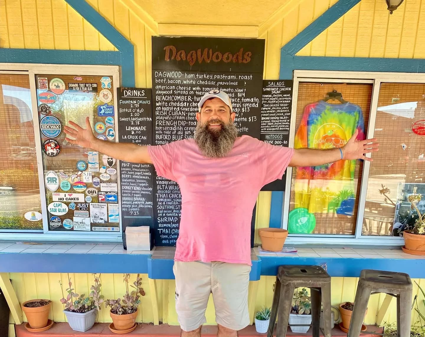 J.R. at the order window beside the chalkboard menu
